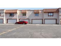 Exterior view of a townhome garages featuring red car and desert landscaping at 1312 Rawhide St, Las Vegas, NV 89119
