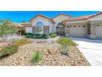Charming single-story home featuring desert landscaping, stone accents, and a secure gated front entry at 1432 Castle Crest Dr, Las Vegas, NV 89117