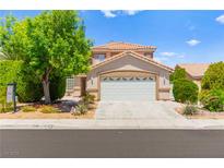 Charming two-story home featuring a well-manicured lawn and a two-car garage at 1540 Singing Bird Ln, North Las Vegas, NV 89031