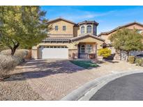 Charming two-story home with a brick driveway, landscaped yard, and an attached two-car garage at 232 Delighted Ave, North Las Vegas, NV 89031