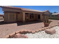 Inviting backyard featuring a covered patio, desert landscaping, and comfortable outdoor space at 2501 Maddington Dr, Las Vegas, NV 89134