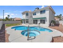 Beautiful in-ground kidney shaped pool and hot tub combination in a backyard with desert landscaping and partial grass at 3604 N Campbell Rd, Las Vegas, NV 89129