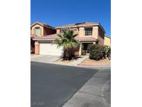 Two-story home featuring a desert landscape with a palm tree and a two-car garage at 5456 Raccoon Valley Ln, Las Vegas, NV 89122