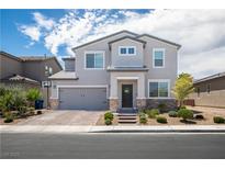 Beautiful two-story home with gray stucco, a brick driveway, manicured front yard, and a two-car garage at 5733 Coral Sun St, North Las Vegas, NV 89031
