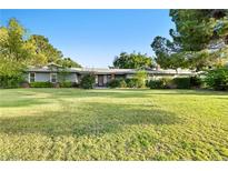 A ranch style home with a sprawling front lawn, mature trees, and a charming, welcoming facade at 7545 Constantinople Ave, Las Vegas, NV 89129