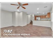 A bright and airy living room with wood-look tile flooring and a ceiling fan at 7632 Calico Fields St, Las Vegas, NV 89149