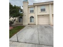 A two-story townhome with a private driveway and an attached one-car garage at 7969 Cina Ave, Las Vegas, NV 89147