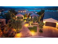 Stunning exterior view of a luxury home with brick driveway, professional landscaping, and lake view at 8 Laricola Ct, Henderson, NV 89011