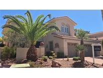 Two-story home featuring a neutral color palette, well-manicured landscaping, and desert-friendly plants and decorative rocks at 8205 Taos Paseo Ave, Las Vegas, NV 89128