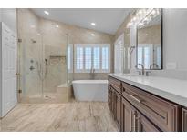 Bright bathroom features a modern soaking tub, glass enclosed shower, and double sink vanity at 8437 Apple Hill Ct, Las Vegas, NV 89128