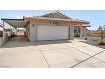 Home with a two-car garage and large driveway at 1261 S Comstock St, Pahrump, NV 89048
