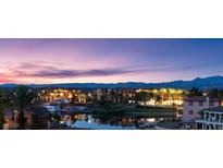 Beautiful lakefront homes with palm trees, lights and dock, and desert mountains in the background at sunset at 20 Via Paradiso St, Henderson, NV 89011