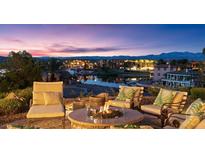Relaxing outdoor lounge featuring plush seating, a fire pit, and serene lake views at sunset at 20 Via Paradiso St, Henderson, NV 89011