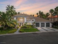 Luxurious house with a beautiful front yard, lush landscaping, decorative driveway, and a three-car garage at 21 Sawgrass Ct, Las Vegas, NV 89113