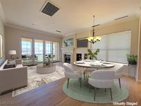 Bright living room with fireplace, dining area, and access to outdoor balcony with lake views at 21 Via Visione # 206, Henderson, NV 89011