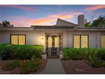 Charming front entrance featuring a decorative security gate, lush landscaping, and a well-maintained exterior at 2479 Domingo St, Las Vegas, NV 89121