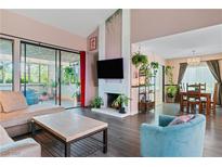 Bright living room with dark floors, fireplace, and sliding door to outdoor seating area at 2479 Domingo St, Las Vegas, NV 89121