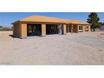 Unfinished home with plywood exterior and two-car garage at 2561 Red Rock Dr, Pahrump, NV 89048