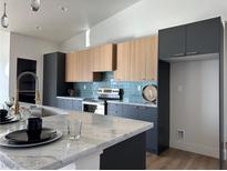 Modern kitchen featuring a waterfall island, stylish cabinetry, and stainless steel appliances at 2561 Red Rock Dr, Pahrump, NV 89048