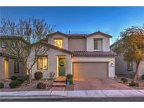Charming two-story home with a well-maintained front yard, beautiful plants, and a two-car garage at dusk at 3213 Molinos Dr, Las Vegas, NV 89141