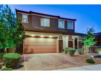 Charming two-story home showcasing a well-manicured front yard and a two-car garage with brick-paved driveway at 361 Cooper Hawk Ct, Las Vegas, NV 89138