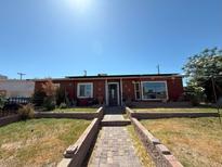 Charming single-story home featuring a well-manicured yard and brick pathway leading to the front door at 4559 S Nellis Blvd, Las Vegas, NV 89121