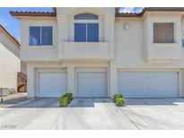 Three car garage showing the exterior of this light colored two-story townhouse at 4800 Grey Wolf Ln # 202, Las Vegas, NV 89149