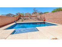 Private in-ground pool in backyard with a view of the desert landscaping at 5079 Quiet Falls Ct, Las Vegas, NV 89141