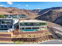 Stunning multi-level home boasts a modern design, pool, and panoramic mountain views at 677 Overlook Rim Dr, Henderson, NV 89012