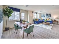 Bright open-concept living and dining area with modern furniture and large windows at 7935 Pandora Sky St # 381, North Las Vegas, NV 89084