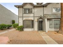Charming two-story townhome featuring a gray exterior with decorative trim and a well-maintained front yard landscape at 875 Rhinegold Way, Las Vegas, NV 89110