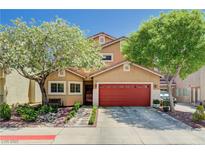 Charming two-story home boasts a vibrant red garage door and mature trees in the landscaped front yard at 9370 Corkfish St, Las Vegas, NV 89178