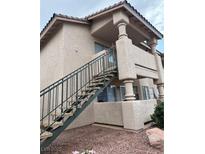 Beige apartment building with stairs leading to a balcony; natural light and modern architecture at 1320 Driscoll Dr # 202, Las Vegas, NV 89128