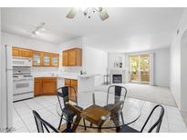 Inviting living space featuring a dining area, kitchen, and a cozy fireplace with access to an outdoor balcony at 1830 N Buffalo Dr # 2014, Las Vegas, NV 89128