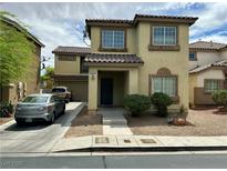 Two-story home with tan stucco exterior, tile roof, covered porch, and landscaped front yard at 4858 Longshot Dr, Las Vegas, NV 89122