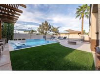 This backyard has a crystal blue pool, a fire pit and a lounge area perfect for entertaining at 5210 Villa Dante Ave, Las Vegas, NV 89141