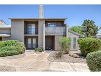 Condo exterior featuring stucco walls, chimney, small balcony, and desert landscaping at 526 Sellers Pl, Henderson, NV 89011