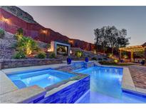 Inviting backyard featuring a sparkling pool and spa with an outdoor television and landscaped surroundings at 5635 Mesa Mountain Dr, Las Vegas, NV 89135