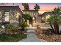 Inviting home featuring desert landscaping and palm trees against a colorful sunset sky at 7206 Laramie Ave, Las Vegas, NV 89113