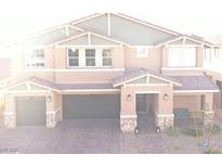 Charming two-story home with a three-car garage, a stone veneer and a well manicured brick driveway at 7855 Skyler Falls Ln, North Las Vegas, NV 89084