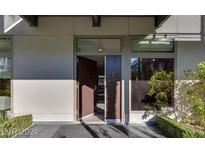 Inviting modern home featuring an open front door and lush landscaping enhancing the property's curb appeal at 8925 W Flamingo Rd # 117, Las Vegas, NV 89147