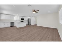 Open-concept living space features a ceiling fan, wood floors, and seamlessly connects the kitchen and living areas at 952 Balzar Ave, Las Vegas, NV 89106