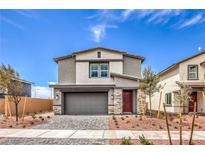 Charming two-story home boasts a modern exterior, landscaped yard, and a welcoming red door at 1011 Gentle Swan St # Lot 697, Henderson, NV 89011