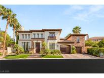 Stunning two-story home showcasing lush landscaping and an attached garage, creating a welcoming curb appeal at 10301 Orkiney Dr, Las Vegas, NV 89144