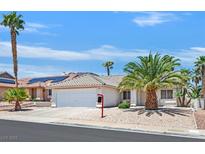 Charming single-story home featuring mature palm trees, a two-car garage, and low maintenance desert landscaping at 130 Park Ridge Ln, Henderson, NV 89002