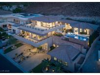 Expansive three-story home featuring balconies, a pool with a spa, manicured grounds and a large driveway at 1683 Tangiers Dr, Henderson, NV 89012