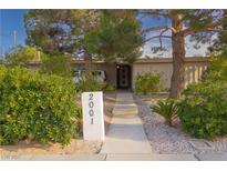 Charming home featuring mature trees, lush landscaping and a welcoming walkway to the front door at 2001 E Mcwilliams Ave, Las Vegas, NV 89101