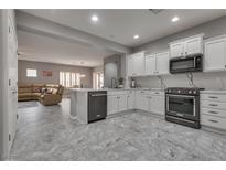 Modern kitchen features white cabinetry, stainless steel appliances, and marble countertops at 4204 Sprints Race Ave, North Las Vegas, NV 89084