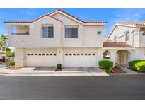 Charming townhome featuring white stucco, red tile roof, and spacious two-car garages at 5201 S Torrey Pines Dr # 1221, Las Vegas, NV 89118