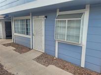 A cozy condo featuring wood paneling, security door, a double-paned window, and a small garden box window at 5335 Rod Ct # 102, Las Vegas, NV 89122
